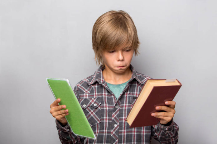 Мальчик с бумажной и электронной книгами //Фото с сайта tlum.ru